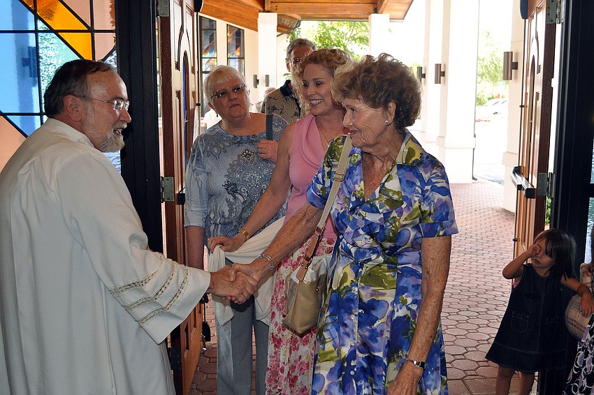 Anne Angers congratulates Msgr. Joseph Stearns on his 40th anniversary.
