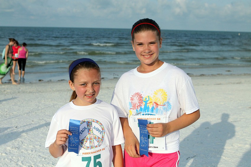 Ally Sabol, 8, and Mikayla Burkholder, 11, with their 1-mile fun run ribbons.