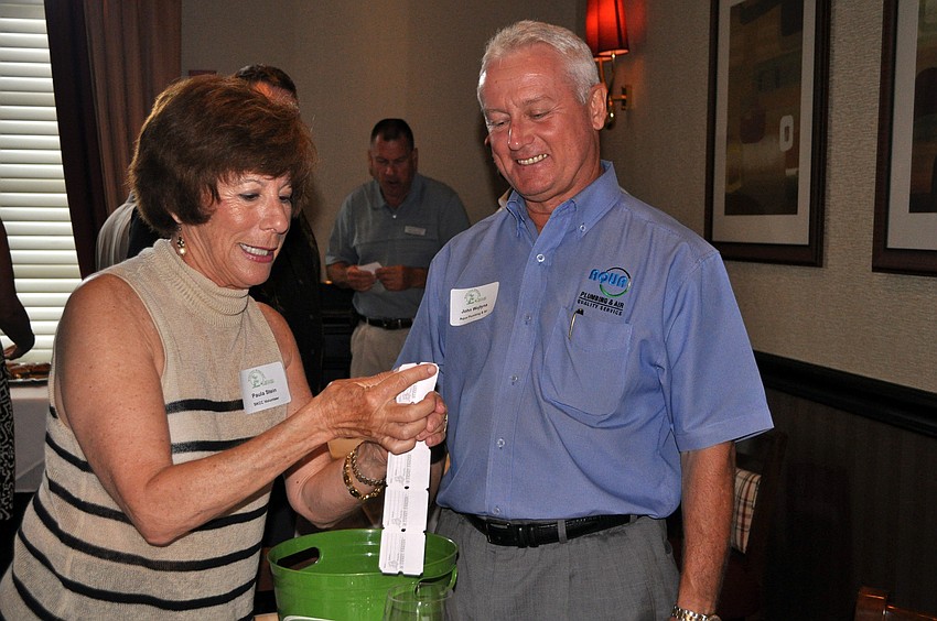 Paula Stein sells some 50/50 raffle tickets to John Wojtyna, Thursday, July 19, at the Siesta Key Chamber of Commerceâ€™s gathering at Ruthâ€™s Chris Steak House.