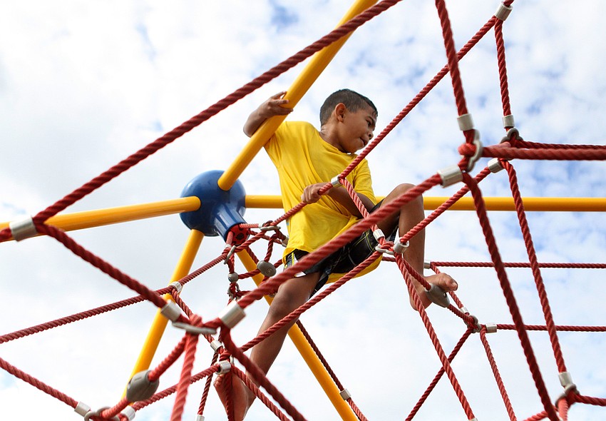 Thomas Garcia, 6, has fun climbing around in the spider web.