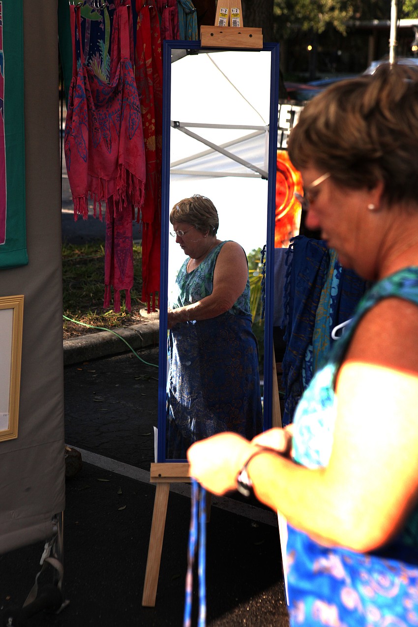 Dottie Schell tries on a skirt at Batik Blissâ€™ tent Sunday, Sept. 1 at the Siesta Key Farmers Market.