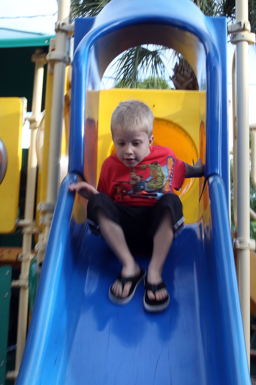 Aidan White, 5, makes his way down the slide.