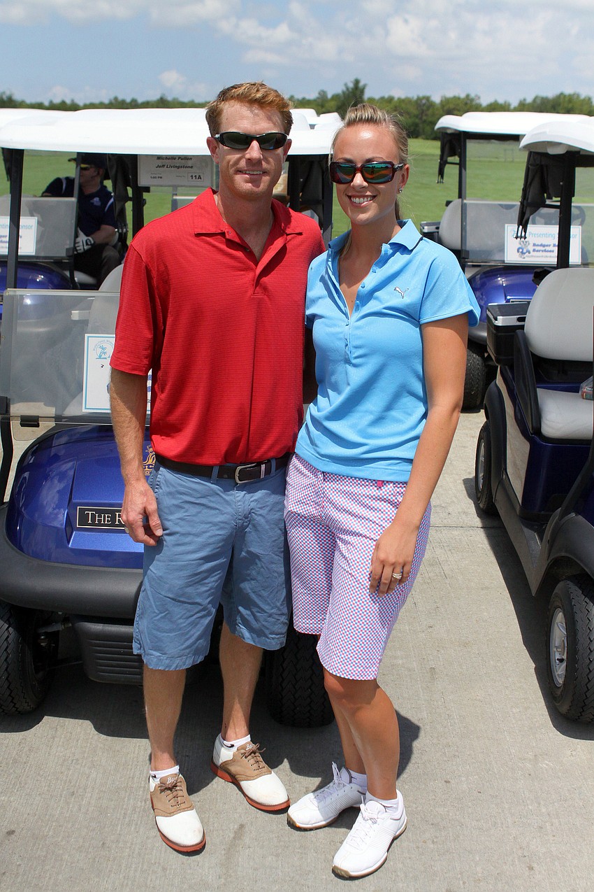 Eric and Michelle Pullen pose in front of their golf cart.