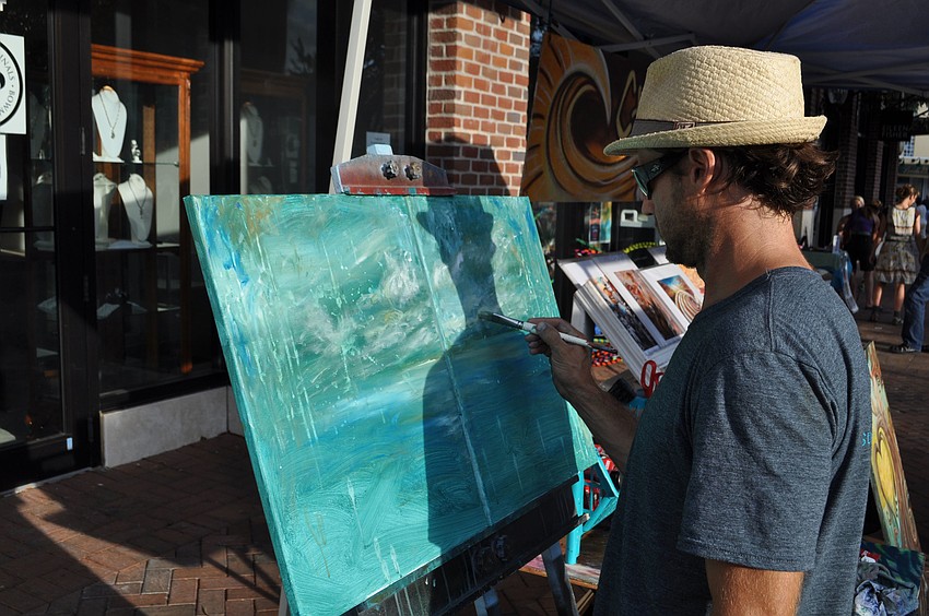 Artist Chad Ruis works on a painting.
