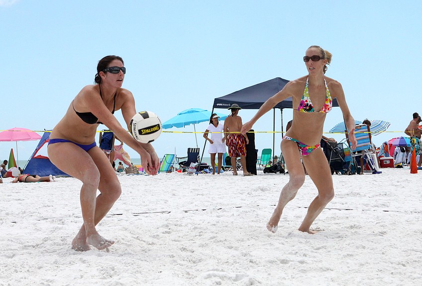 Heidi Miller bumps the ball as Kim Whitney prepares to help get it over the net.