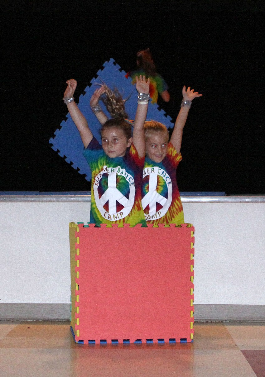 Lily Hayes, 7, and Emma Wadle, 7, jump out of a make-shift box at the beginning of the dance to â€œWe run the nightâ€.