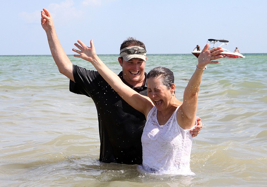 Leslie Ambrosio raises her hands up in the air after being baptized by Pastor Craig King, Sunday, July 30.