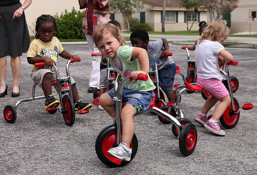 Isabella Wiseman, 2, center, and the other toddlers have fun riding around on their new tricycles, Tuesday, Aug. 7, at Pines of Sarasota.
