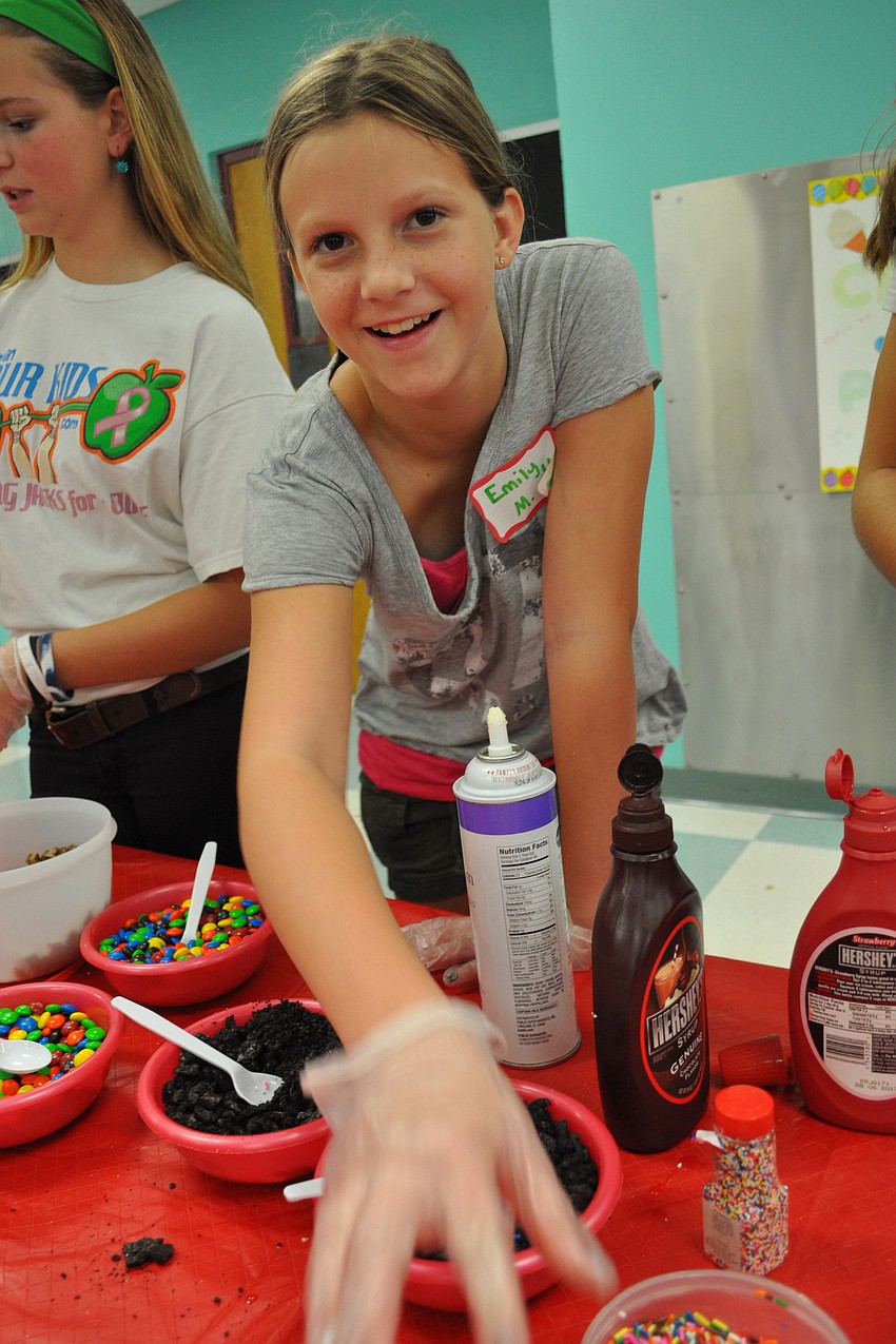 Braden River Middle School student Emily Manning add sprinkles and other toppings to guests' ice cream.