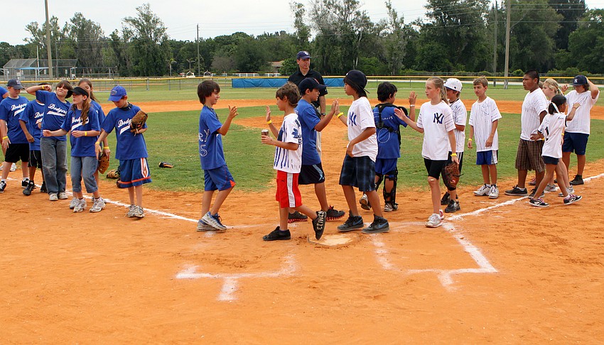 The 1947 Brooklyn Dodgers and the 1947 New York Yankees give each other high fives after playing their World Series game Friday, April 29 at Twin Lakes.