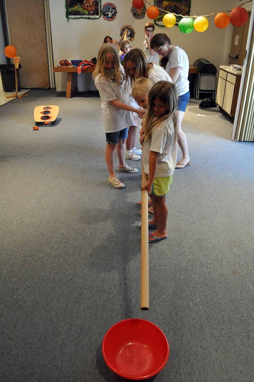 Campers work together to send a ball through a series of tubes.