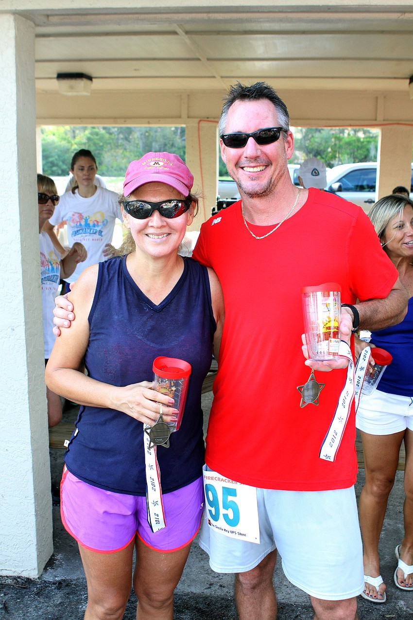 Masters winners Doris Goodman and Rob Loeffler show off their medals and special Tervis Tumblers.