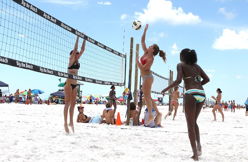 Aurora Newguard jumps to spike the ball over the net while Melissa Moore prepares to block and Newguardâ€™s teammate, Elle Santos, looks on, Saturday, July 14.