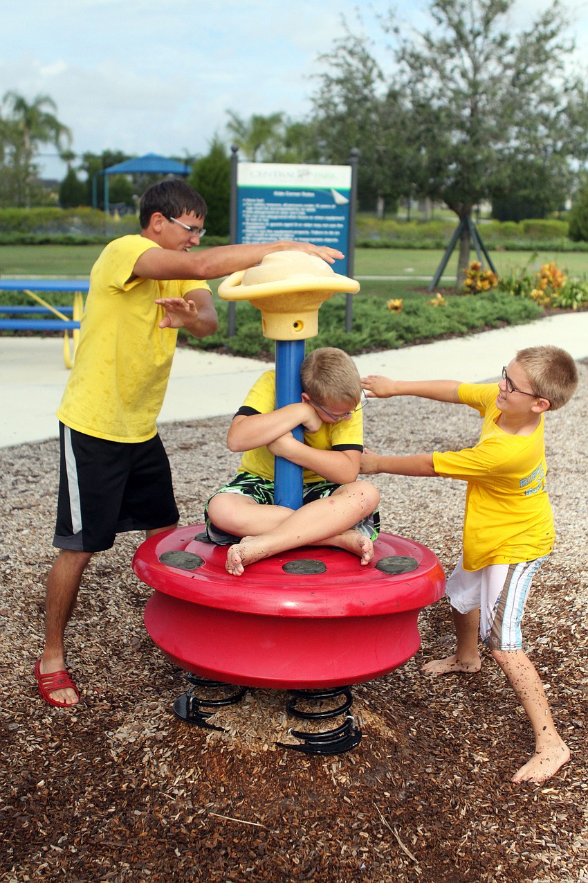 Camp counselor Caleb Suttle and Noah Bean, 10, spin Thomas Joy, 10, Wednesday, July 18.