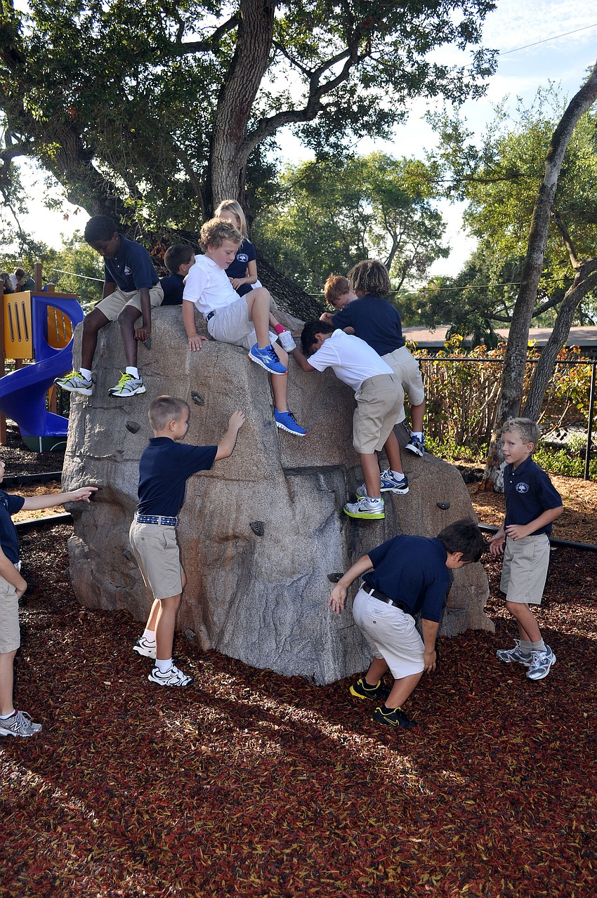 Out-of-Door Academy students play on the bigger of the two rock walls on the newly renovated lower school playground, Wednesday, Aug. 22, the first day back to school.