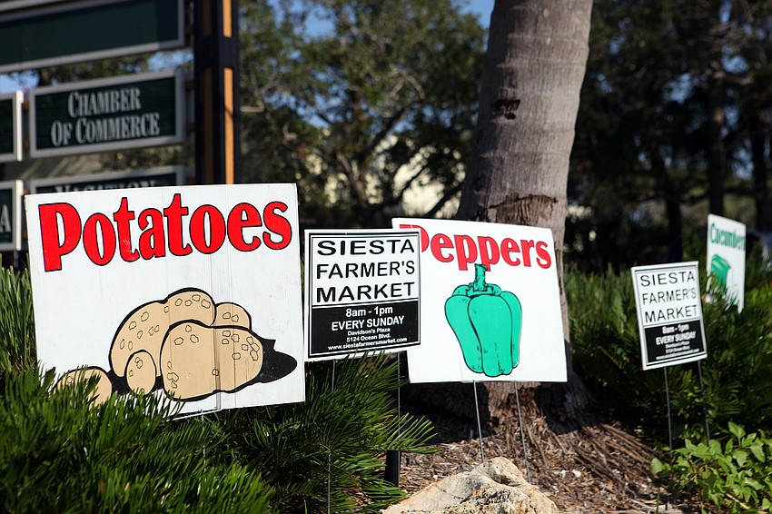 A variety of signs promoting the farmers market and the items sold there were on display around the Siesta Village Plaza parking lot.