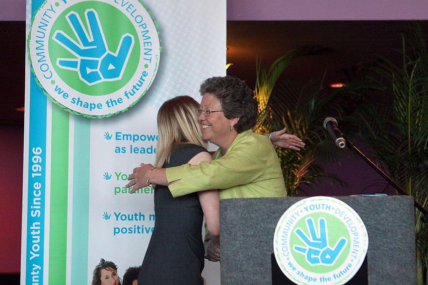 Cassandra LaBanty hugs Karen Bogues after winning the Karen Bogus Community Service Award.