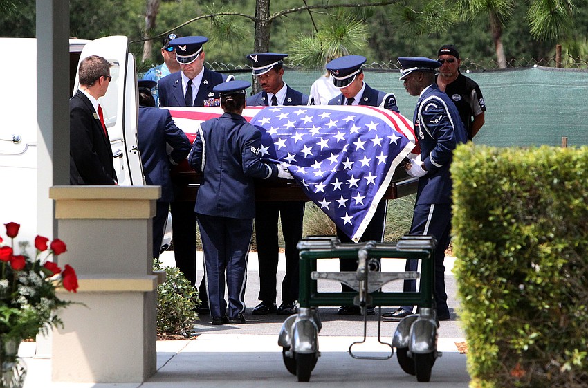 Chief Albert Hogleâ€™s casket is lifted out of the hearse at the Sarasota National Cemetery.