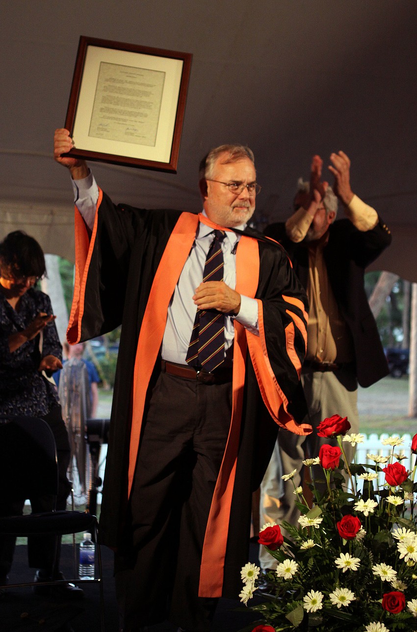 President Michalson holds up his honorary degree.