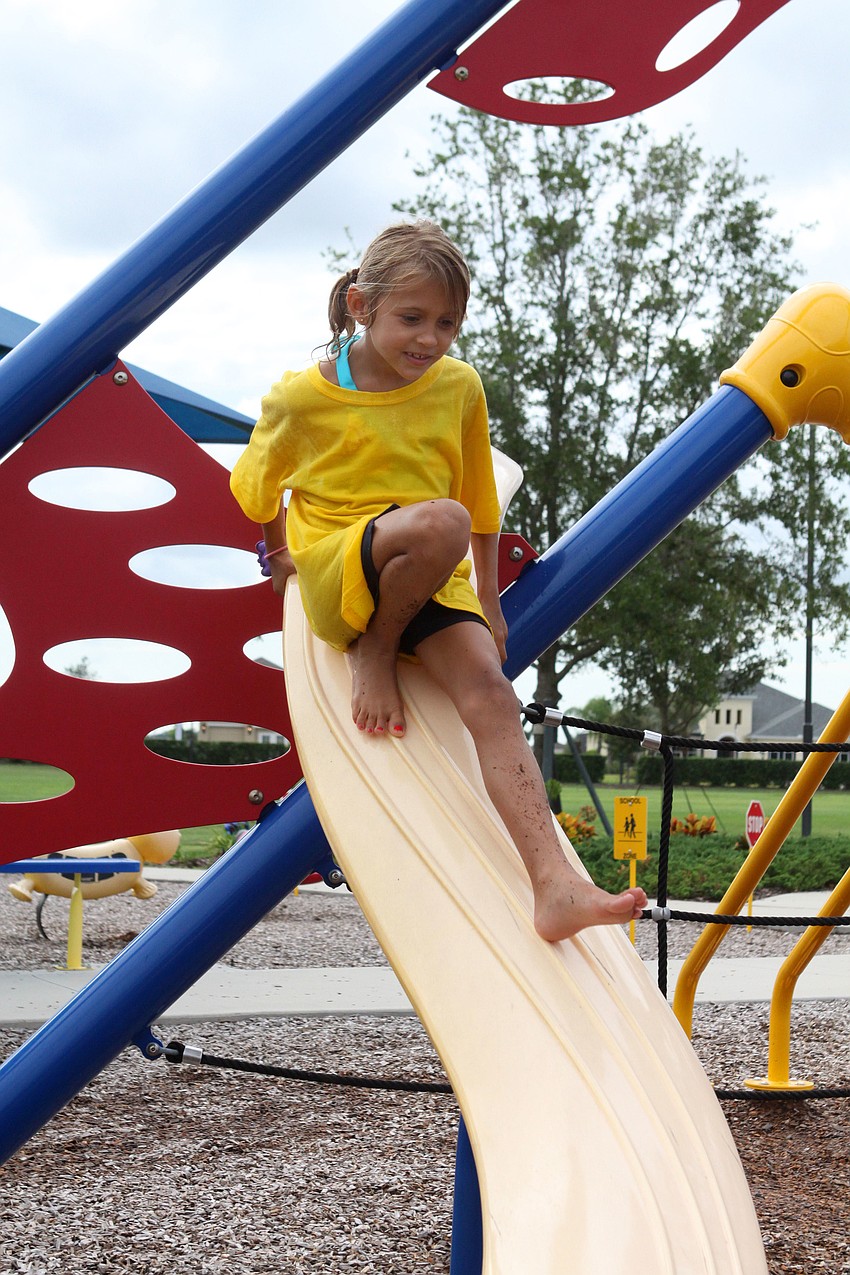 Sage Scrimle, 7, slides down a piece of playground equipment, Wednesday, July 18, out at Central Park during Bible Baptist Summer Camp.