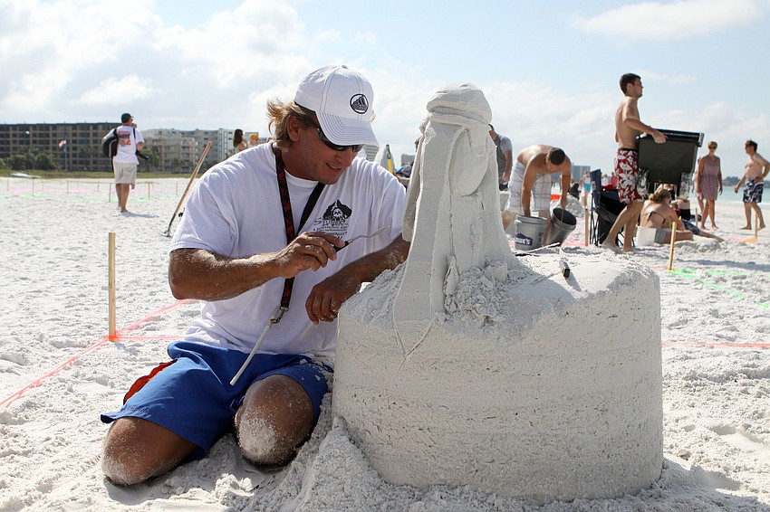 Andrew Dailey works on sculpting his piece â€œPirecanâ€, Saturday, May 5, during the 40th Annual Sand Sculpting Contest.