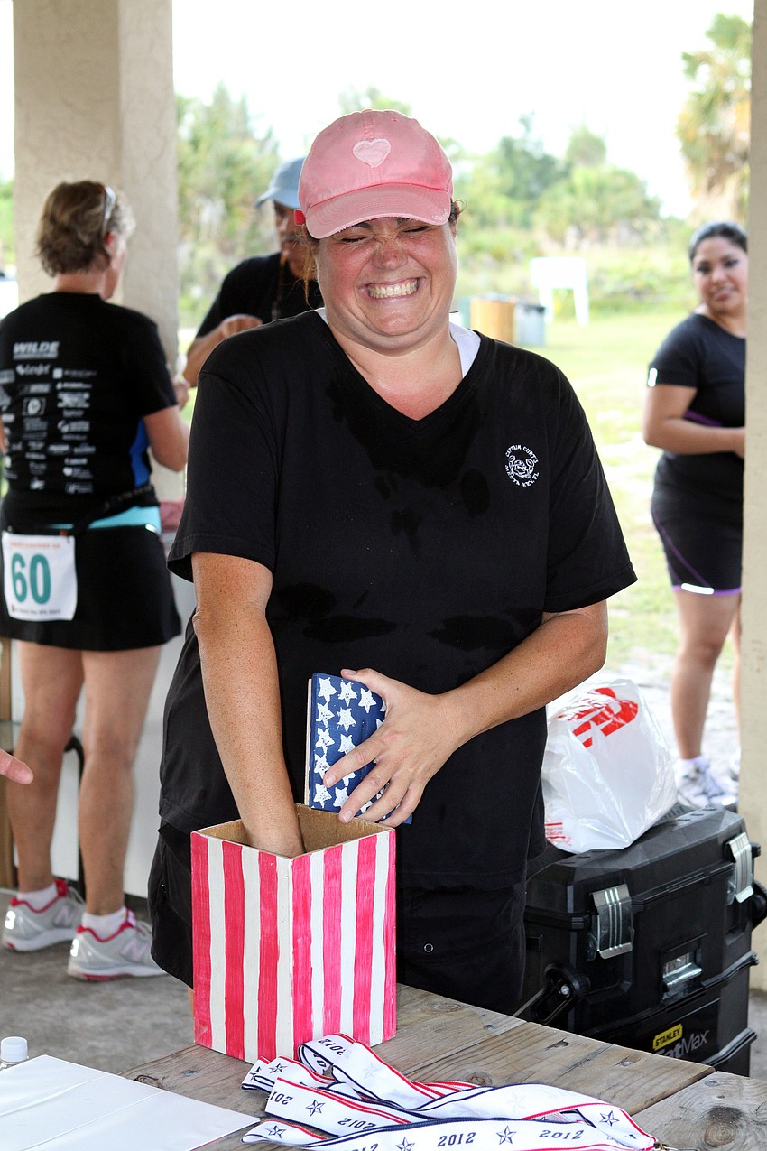 Alana Tomasso reaches in to pick out the winner of the raffle to detonate the Fourth of July Fireworks on Siesta Key.