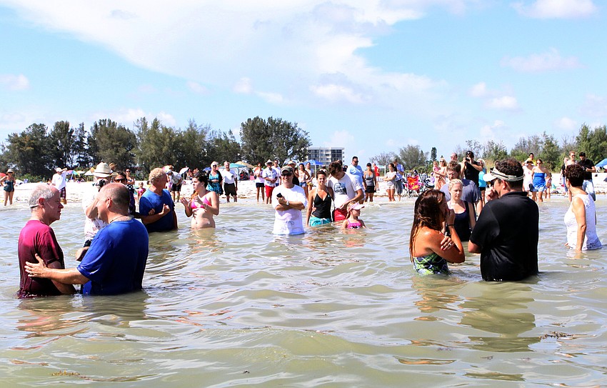 A dozen people were baptized in the Gulf of Mexico, Sunday, July 30, in front of their family, friends and congregation.