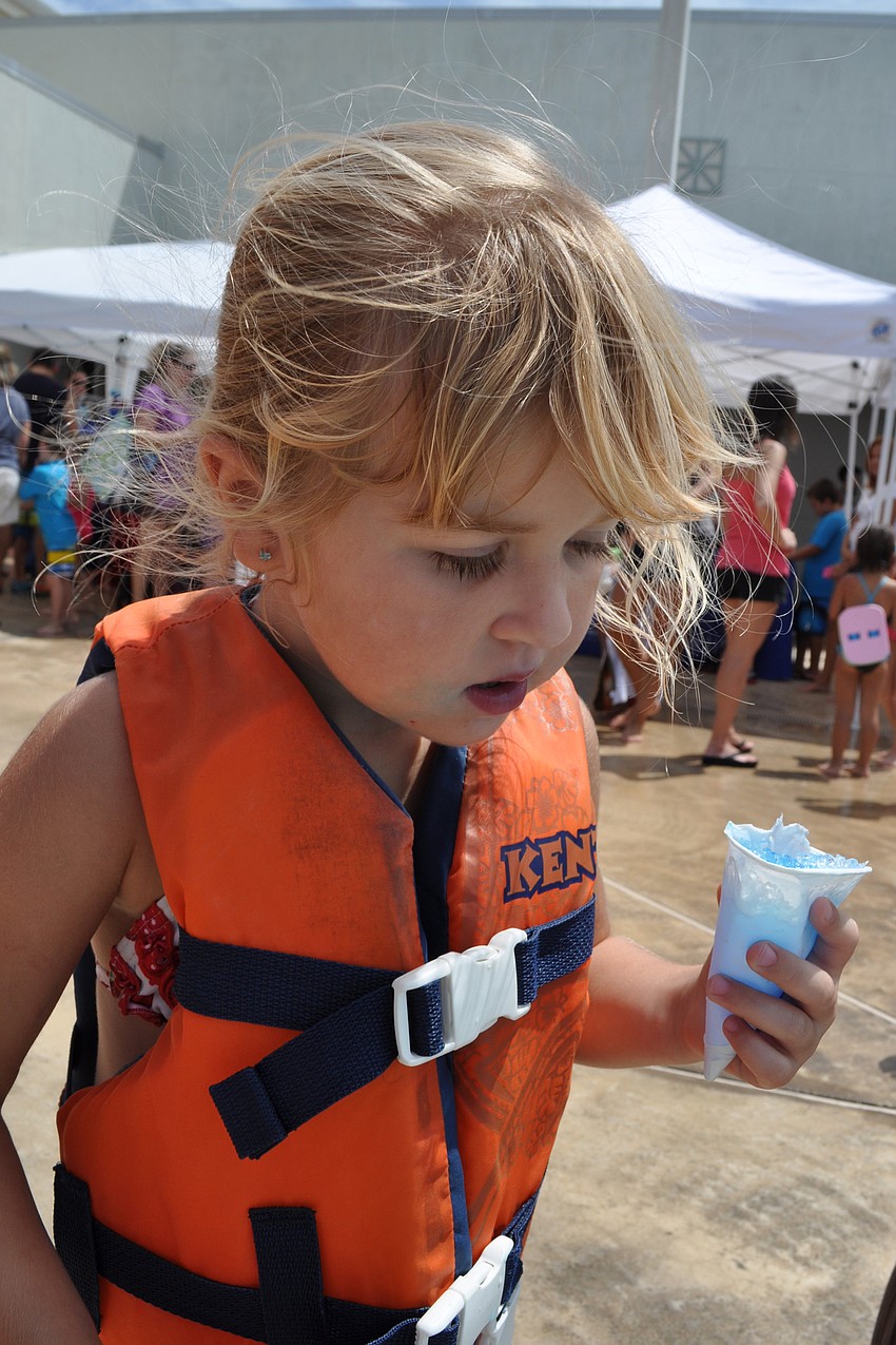 Paytan Allen, 3, enjoys a sno cone while watching the other children swim.