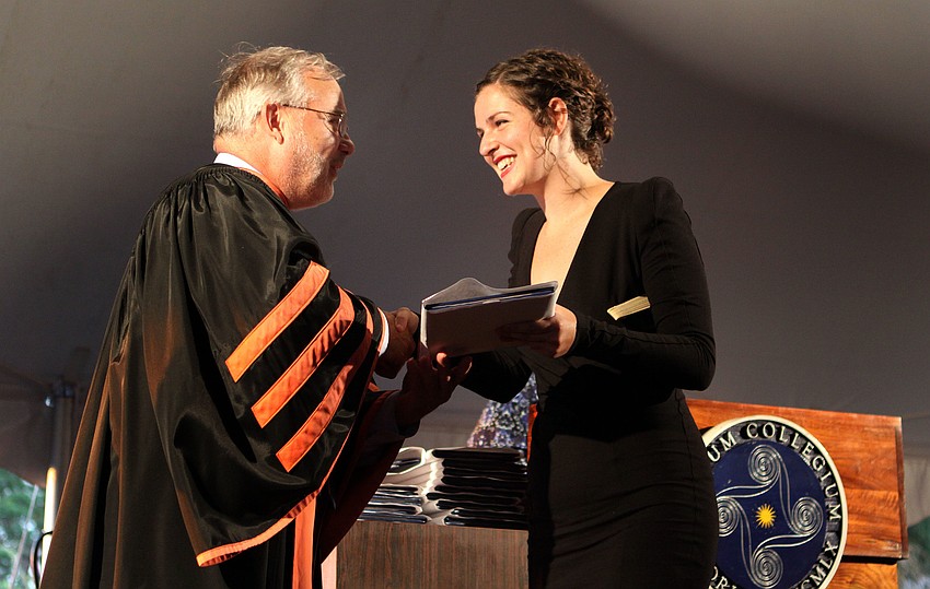 President Michalson presents Aria Grace Alamahodaei with her diploma.