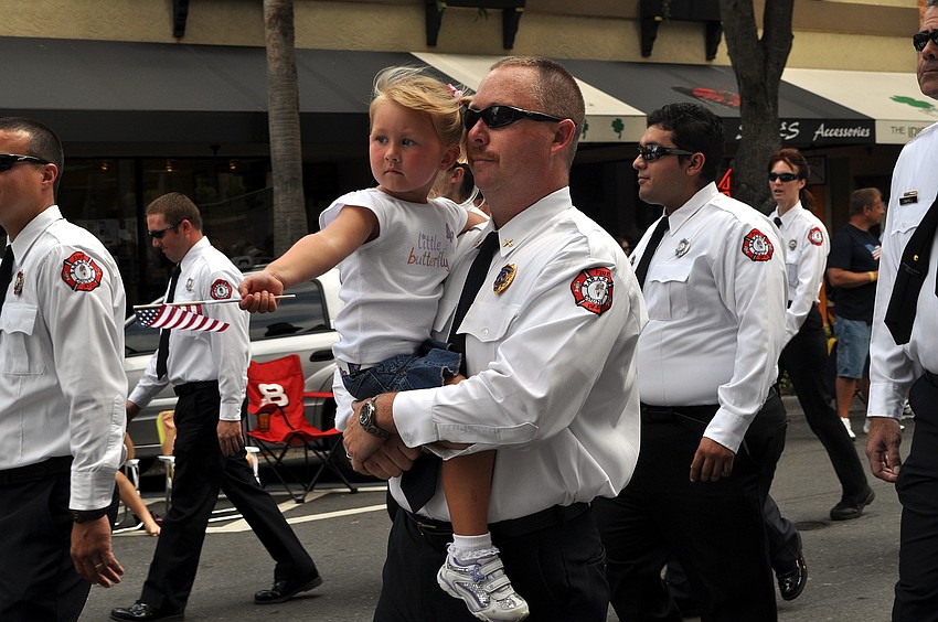 Glenn Snyder carries his daughter, Peyton, 3, throughout the Memorial Day parade, Monday, May 28.