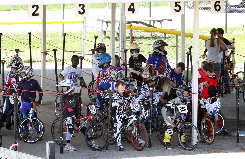 Racers wait at the bottom of the hill in the shade before their races on Olympic Day, Saturday, July 7, at Sarasota BMX.