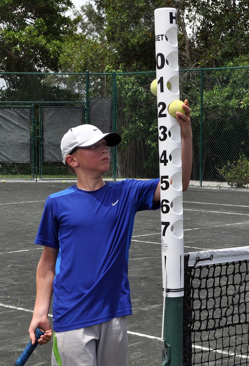 Stefan Stanczuk, 12, changes the score during his match against fellow camper Benjamin Varah, 12, Monday, July 23.