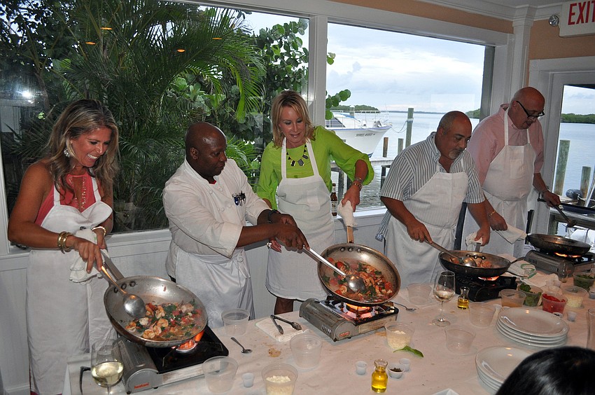 Thomas Petit helps the table of Chris McKee, Jen Allen, Frank Nocco and â€œBig Mikeâ€ Levine during the Taste of the World Interactive Dinner, Friday, Aug. 17, at Pattigeorgeâ€™s.