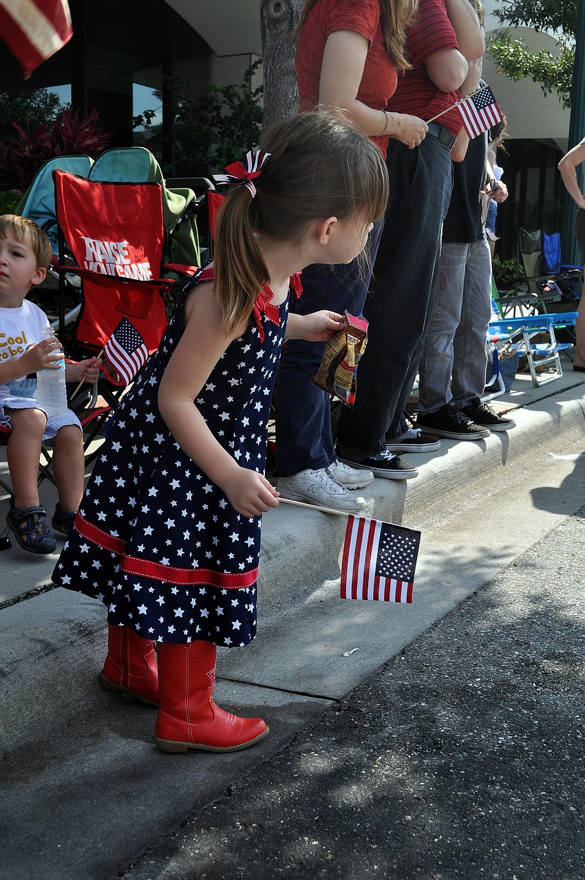 Claire Toale, 4, wore her red, star boats and red, white and blue dress while waving her flag during the Memorial Day parade.