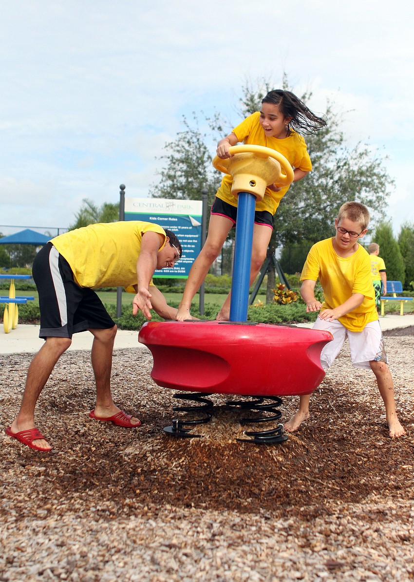 Camp counselor Caleb Suttle and Noah Bean, 10, spin Ruthann Mazullo, 10.
