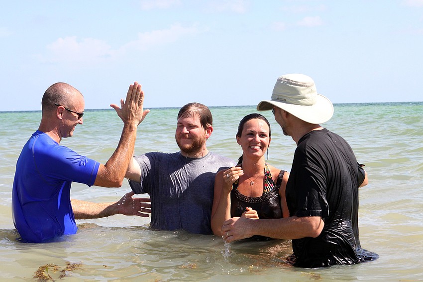 Dave Shephard, Childrenâ€™s Pastor, high fives Justin Robinson, while Debbie Robinson thanks Dan Delzer, Worship Pastor, for baptizing them, Sunday, July 30.