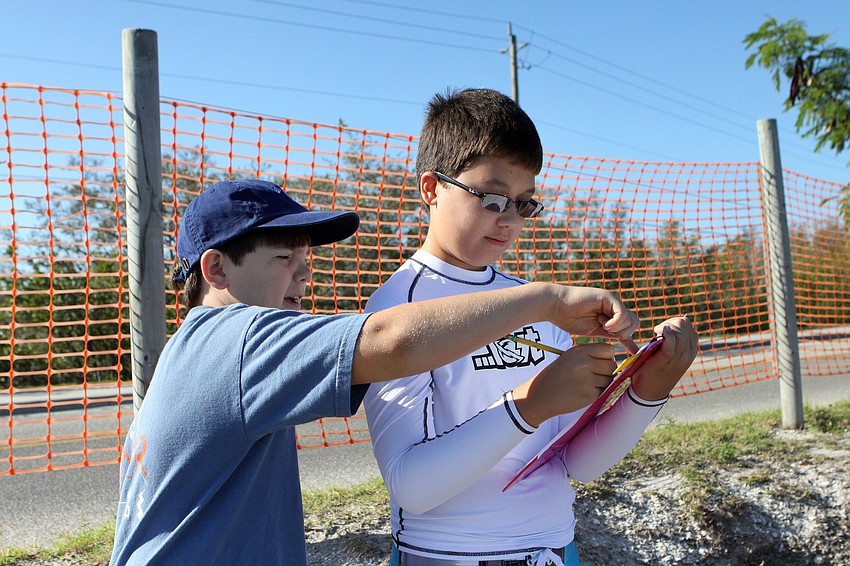 Ryan Appleby, 11, and Misha Fazlutdinov, 12, work on reporting their findings on the diversity and overall number of crabs change from Fall to Spring.
