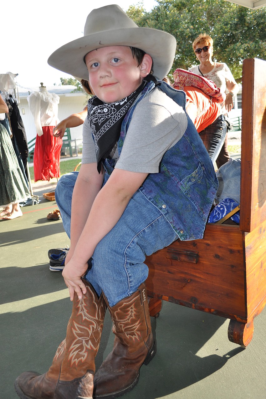 Joey Vogelsong, 7, tries on a pair of cowboy boots.