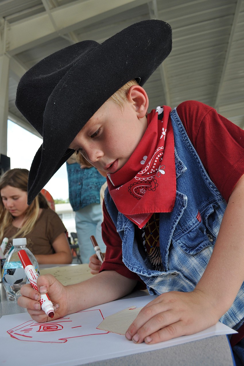 Five-year-old Levi Pelletier draws a barn.