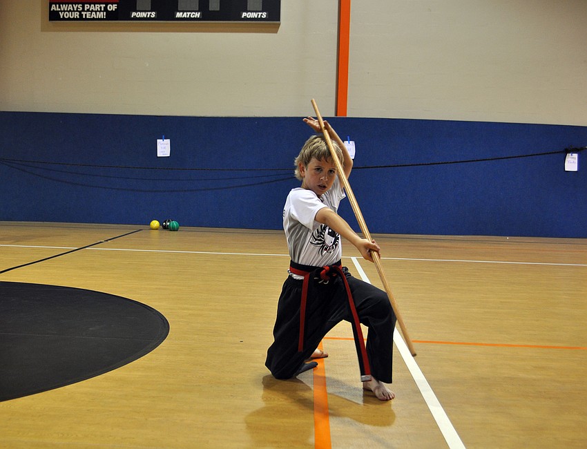 Logan Carlton works on his weapons kata with a bo.