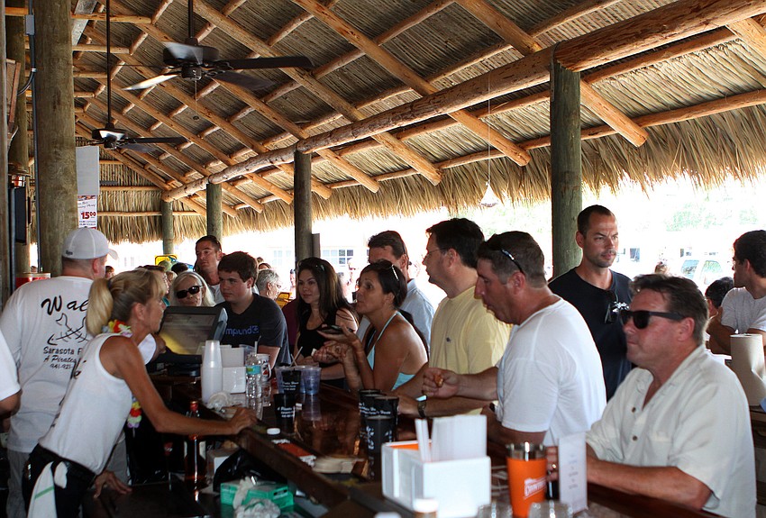 People order up drinks at the bar at Waltâ€™s Fish Marketâ€™s new Chickee Bar, Sunday, May 27.