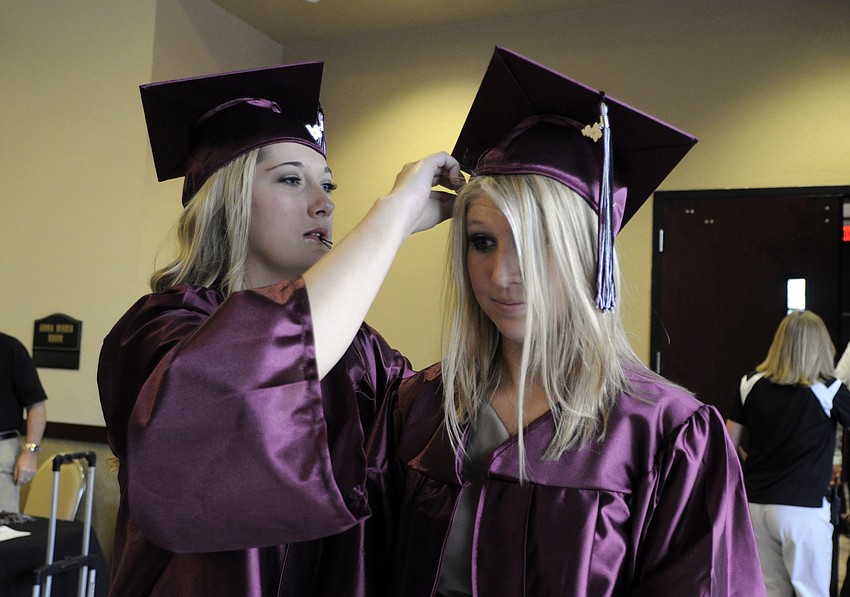 Nicole Hubbard helps Abby Baker with her cap before the start of Braden Riverâ€™s 2012 Commencement Ceremony.