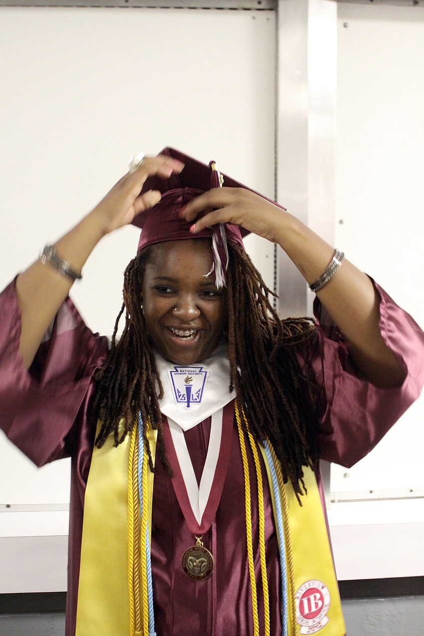 Indigo Alexis works on getting her cap on just right.