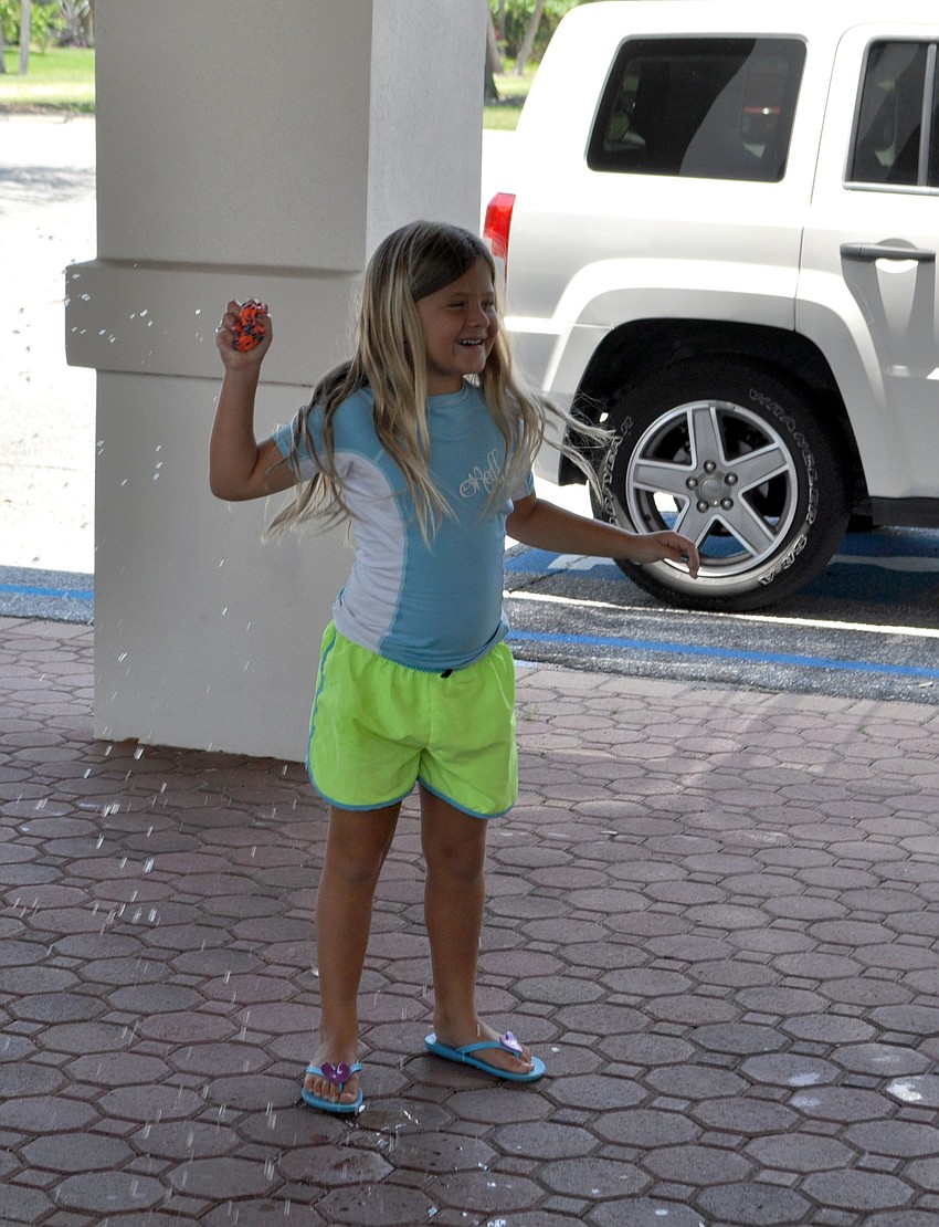 Helena Hebda throws a water-soaked ball at other campers.