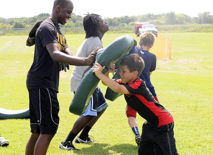 East Manatee Bulldogs middle linebacker Justin Shofter, 9, takes on a Mustangs player during an offensive line drill.