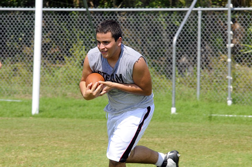 Fifteen-year-old Roberto Valls participates in a running back drill.