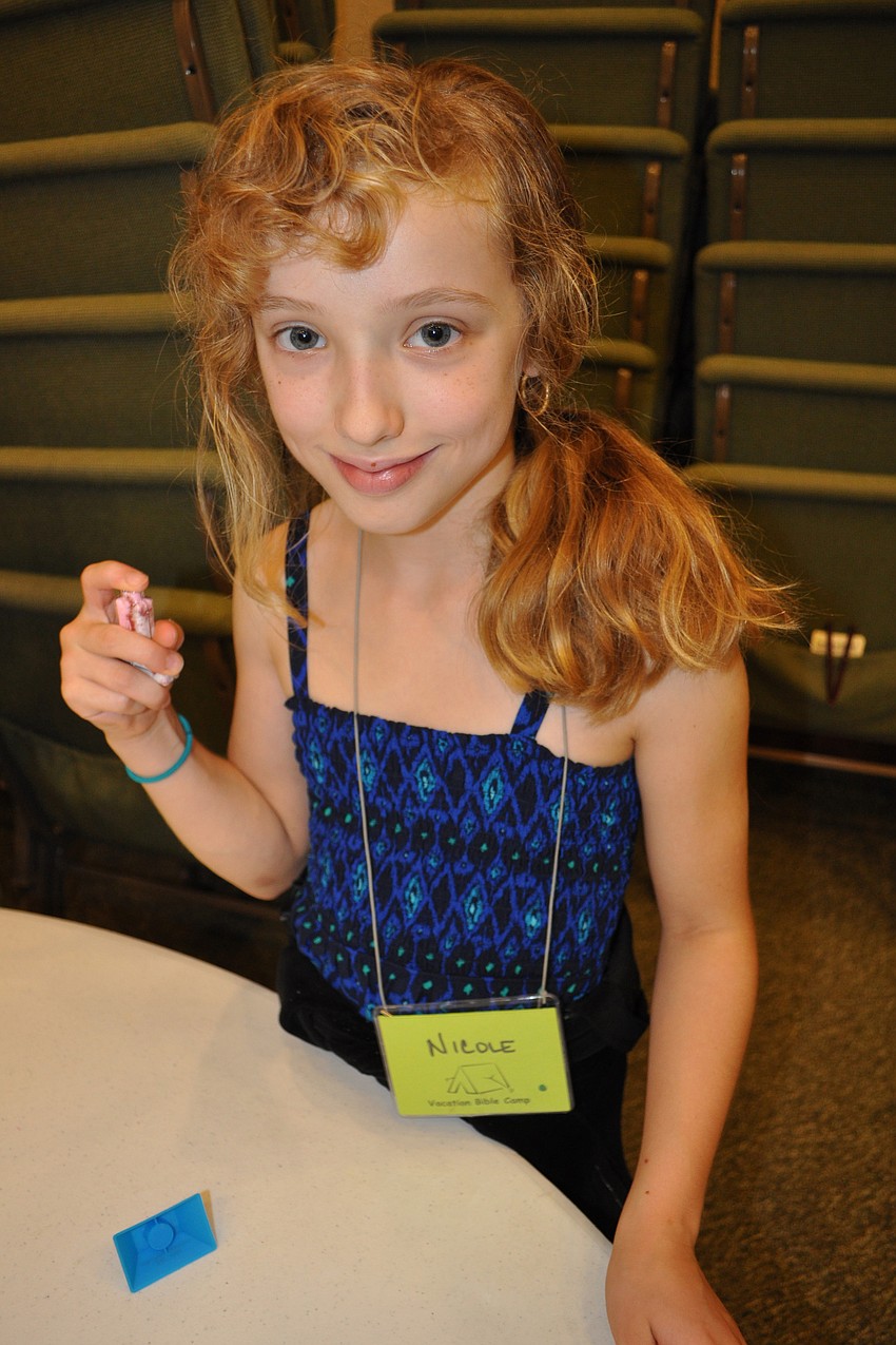 Nicole Ouellette, 9, shook her necklace pendant to mix up the colored sand in it.