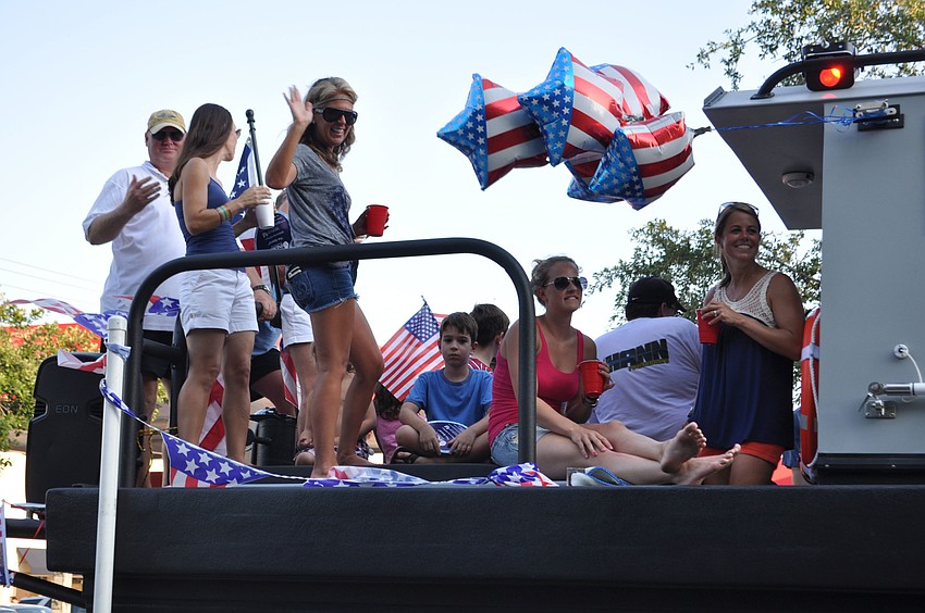 People celebrate on the deck of one of the boats in the parade.