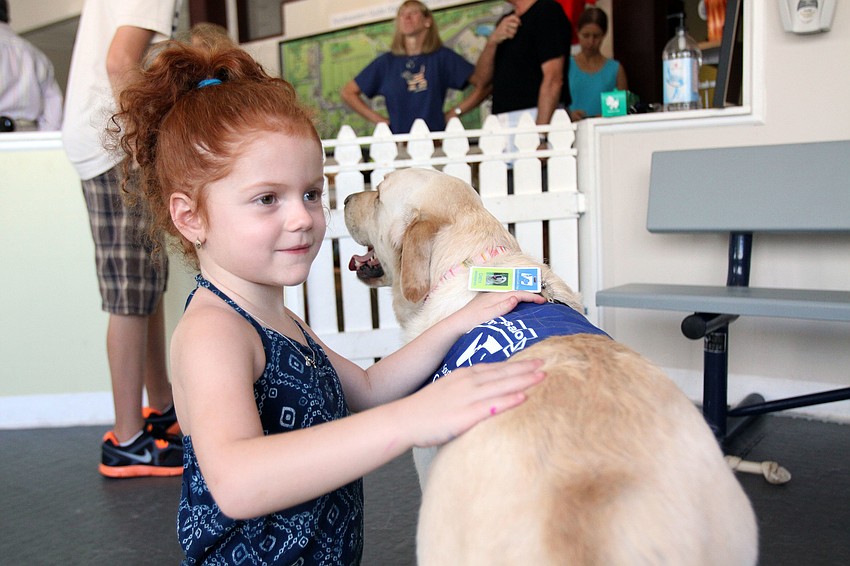 Grace Calore, 5, has fun petting Casey II, Saturday, July 21, during Puppy Love at Southeastern Guide Dogs Sarasota.