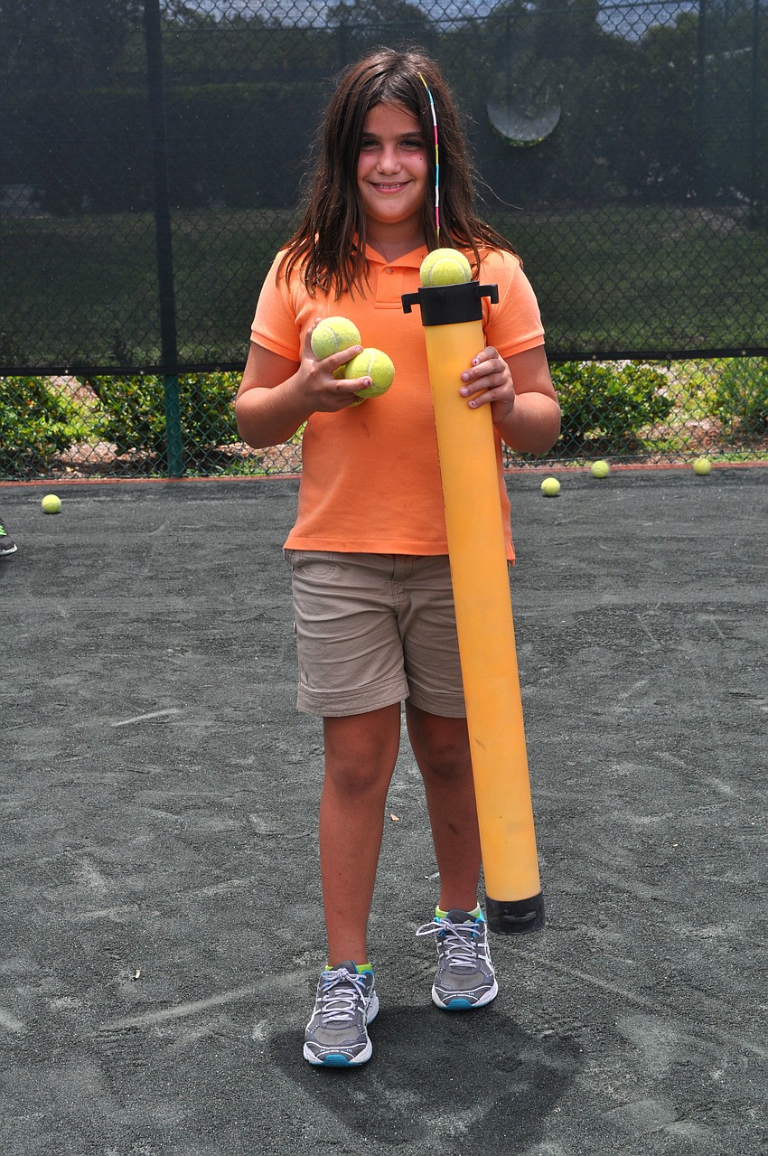 Logan Libertore, 11, had fun picking up balls with the tube, Monday, July 23, during tennis camp at Longboat Key Club Tennis Gardens.